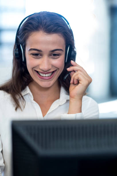 Young woman working on computer with headset in office